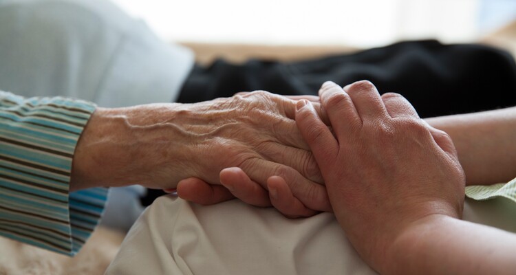 Die Hand einer Pflegekraft hält die Hand eines Bewohners im Altenpflegeheim AGAPLESION BETHANIEN LEIPZIG.